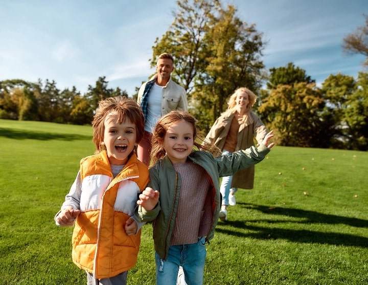 Kids and parents running through a field