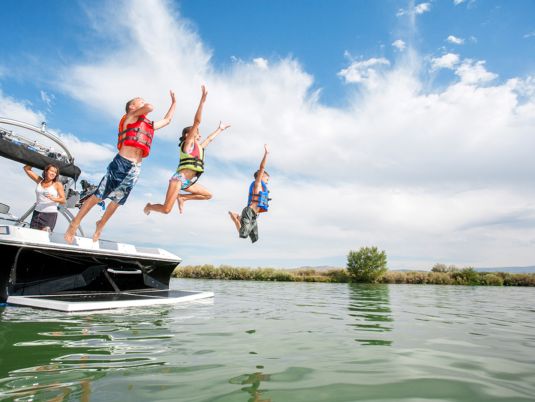 people jumping from a boat into water